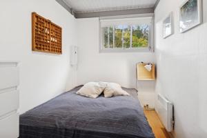 a bedroom with a bed in a white room at Well-Designed House In Scenic Surroundings in Martofte
