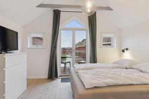 a white bedroom with a large bed and a window at Holiday Apartment With Sea View in Hadsund