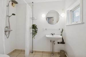 a white bathroom with a sink and a shower at Holiday Apartment With Sea View in Hadsund
