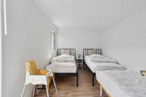 a room with three beds and a chair at Cozy Holiday Home in Nyrup