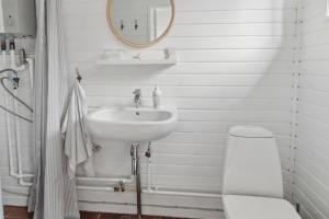 a white bathroom with a sink and a toilet at Cozy Holiday Home in Nyrup +23 photos