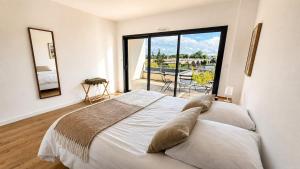 a bedroom with a large bed and a large window at Les Oiseaux de Loire in Les Ponts-de-Cé
