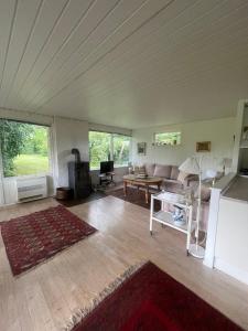 a living room with a couch and a table at Spacious Holiday Home With Large Plot By Buresø in Slangerup