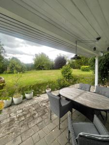 a patio with a wooden table and chairs at Spacious Holiday Home With Large Plot By Buresø in Slangerup