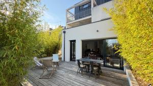 a wooden deck with a table and chairs on it at Les Oiseaux de Loire in Les Ponts-de-Cé