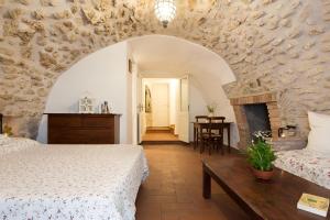 a bedroom with two beds and a stone wall at Nel cuore di Narni - ItalyWeGo in Narni