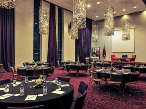 a dining room with tables and chairs and chandeliers at Mercure Nador Rif in Nador +168 photos