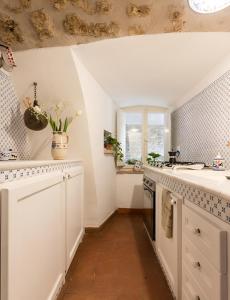 a kitchen with white cabinets and a sink and a window at Nel cuore di Narni - ItalyWeGo in Narni