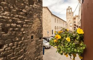 a hanging basket of yellow flowers on the side of a building at Nel cuore di Narni - ItalyWeGo in Narni