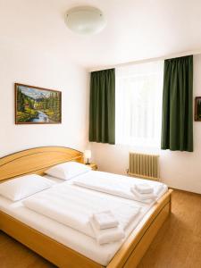 a bedroom with a large white bed in front of a window at Hotel Kaffeemühle in Vienna