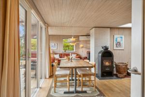 a dining room with a table and a wood stove at Holiday Home And Annex Surrounded By Nature in Ebberup