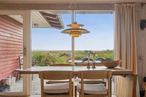 a dining room table with chairs and a large window at Holiday Home And Annex Surrounded By Nature in Ebberup +22 photos