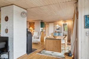 a living room with a kitchen and a living room with a fireplace at Holiday Home And Annex Surrounded By Nature in Ebberup
