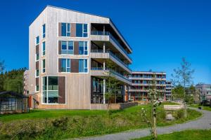 an apartment building on a hill with a tree at Penthouse with Rooftop Terrace & Balcony in Bergen