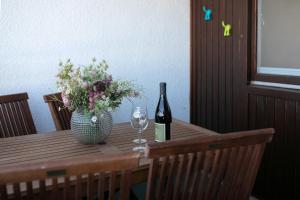 a table with a bottle of wine and a vase of flowers at Strandhotel Dahme TraumMeerBlick in Dahme +22 photos