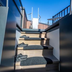 a set of stairs with pairs of shoes on them at Penthouse with Rooftop Terrace & Balcony in Bergen +23 photos