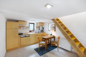 a kitchen with wooden cabinets and a table and chairs at Tiny Appartment Xanten am See in Xanten