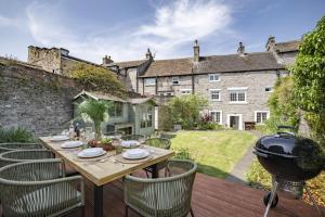 a patio with a table and chairs and a grill at The Old Manse in Leyburn