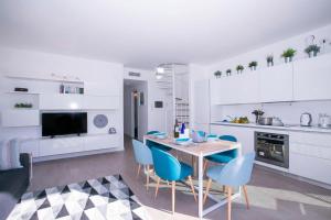 a white kitchen with a table and blue chairs at Casa Laura Apt. 6 in Menaggio +26 photos