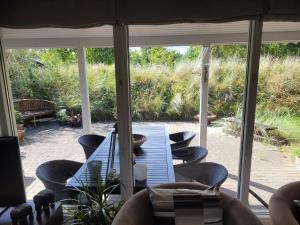 a screened porch with a table and chairs at Natural Plot Fireplace And True West Coast in Thisted