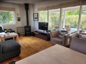 a living room with a tv and a couch and chairs at Natural Plot Fireplace And True West Coast in Thisted