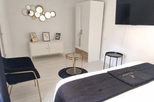 a bedroom with a bed and two chairs in it at Marguerite - Charme et confort in Orange