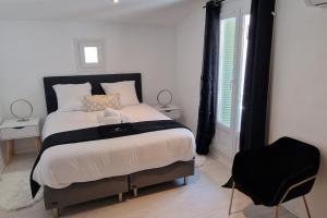 a bedroom with a large bed with a black headboard at Marguerite - Charme et confort in Orange