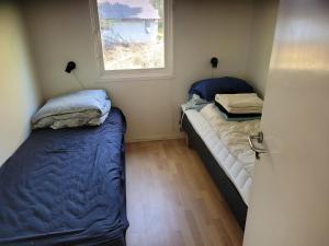 two beds in a small room with a window at Natural Plot Fireplace And True West Coast in Thisted