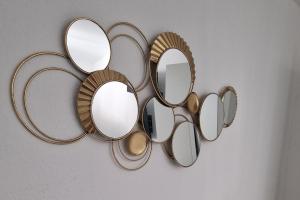 a group of mirrors hanging on a wall at Marguerite - Charme et confort in Orange +3 photos