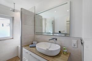 a white bathroom with a sink and a mirror at Fewo-Taunus-Panoramablick in Königstein im Taunus +22 photos