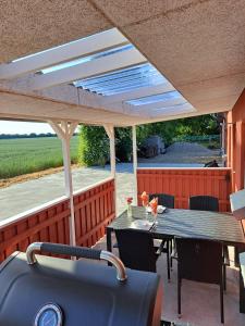 a patio with a table and chairs under a roof at Idyllic Country Apartment Incl All Utilities in Christiansfeld