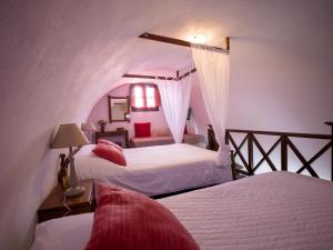 a bedroom with two beds in a room with an attic at Anna Traditional Apartments in Kamari +71 photos