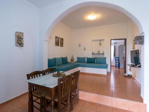 a living room with a blue couch and a table at Anna Traditional Apartments in Kamari