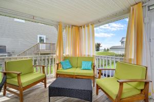 a porch with two chairs and a table at Bertie Street Cottage in Chincoteague