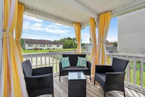 a porch with chairs and a table on a balcony at Bertie Street Cottage in Chincoteague +21 photos