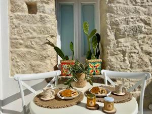 a table with plates of food on a porch at Godano Rooms in Drapia