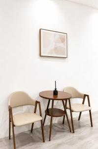 a table and two chairs with a table and a picture at Lawson Inn in Sibu