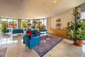 a lobby with a blue couch and a table at Luna Hotel Lago Maggiore Arona in Oleggio Castello