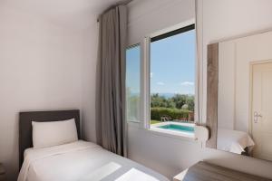 a bedroom with a bed and a window and a pool at Villa Renata -Pool, Large Garden & Free Parking, 2 Minutes Walk from The Beach in Barbati +103 photos