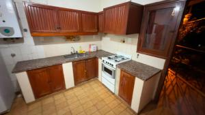 a small kitchen with wooden cabinets and a stove at Dulce descanso 3 Bed and Breakfast in Salta