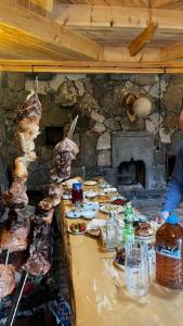 a table with plates of food and a fireplace at Rati's Oda in Aspindza