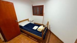 a small bedroom with a bed with a blue sheet at Dulce descanso 3 Bed and Breakfast in Salta +15 photos