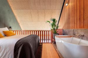 a bedroom with a bed and a bath tub at Lennepserf - T Marsje in Veessen +5 photos