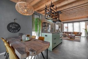 a kitchen and dining room with a wooden table and chairs at Lennepserf - T Marsje in Veessen