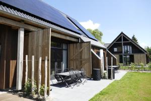 a group of wooden buildings with a table and chairs at Lennepserf - T Marsje in Veessen