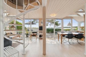 a dining room with a table and chairs and windows at Panoramic View And Denmarks Best Beach in Neksø