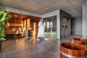 a woman in a white dress walking through a lobby at Lennepserf - De Bok in Veessen