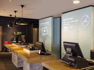 a store with a reception desk with computers on it at ibis London Barking in Barking