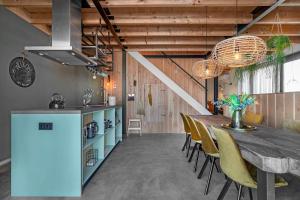 a kitchen and dining room with a long table and chairs at Lennepserf - De Pinkels in Veessen +10 photos