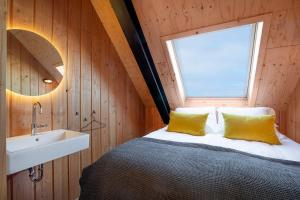 a bedroom with a bed with a sink and a window at Lennepserf - De Pinkels in Veessen